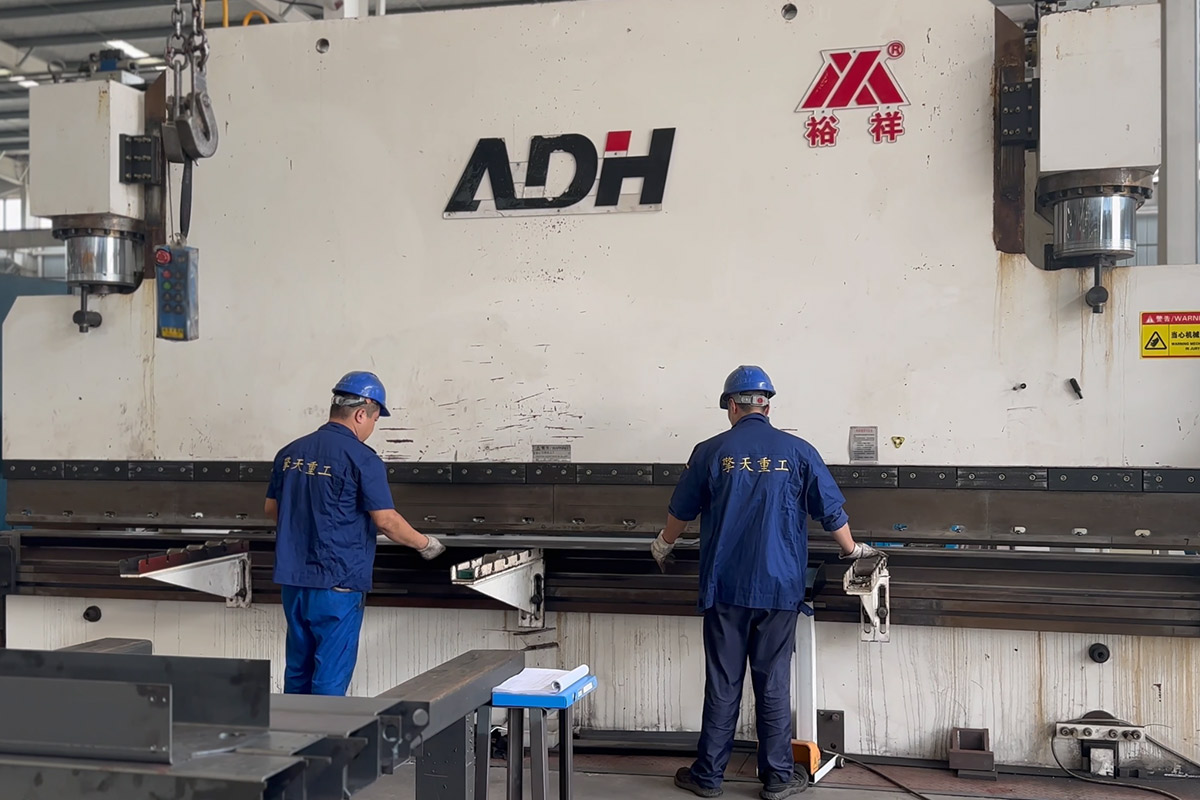 Experienced technicians operating ADH precision press brake for crane boom forming at SKPL-LIFT 40000 sqm facility