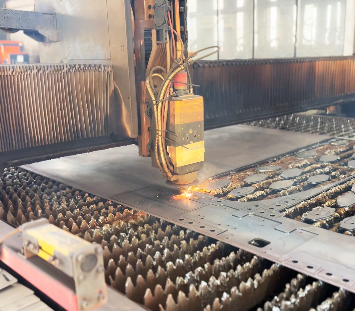 Industrial CNC laser cutting machine processing high-strength steel plates for truck mounted crane manufacturing at SKPL factory